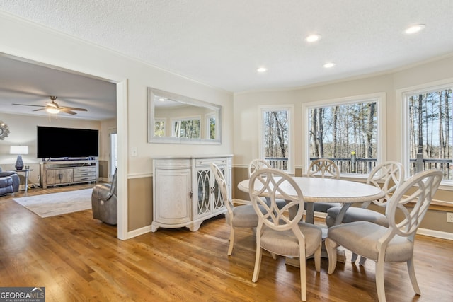 dining space featuring light wood-style floors, ornamental molding, a textured ceiling, and recessed lighting