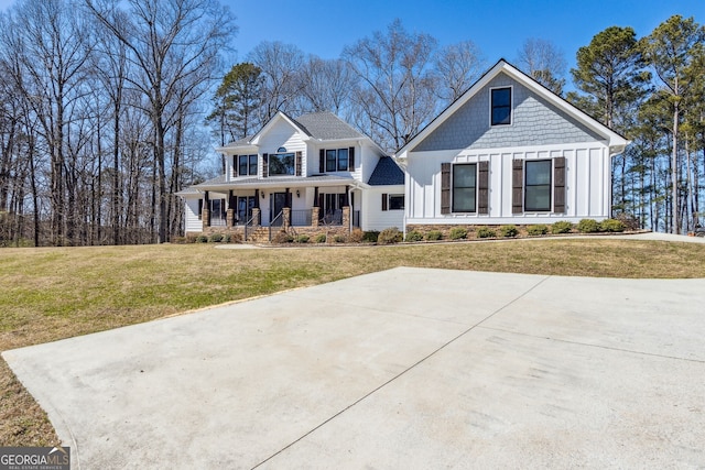 modern inspired farmhouse with a porch, board and batten siding, and a front yard