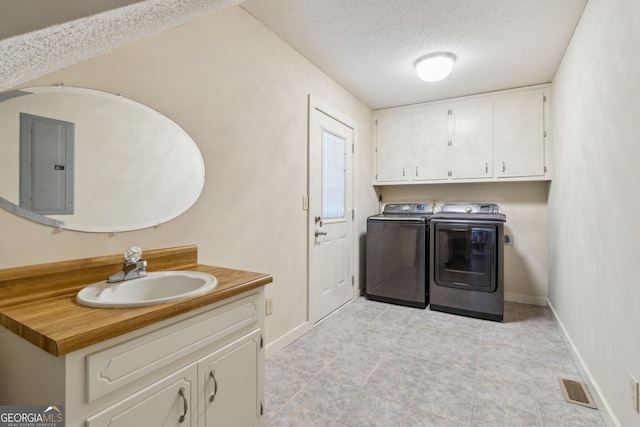 laundry area featuring separate washer and dryer, a sink, visible vents, cabinet space, and electric panel