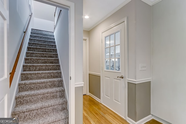 stairs with recessed lighting, crown molding, and wood finished floors