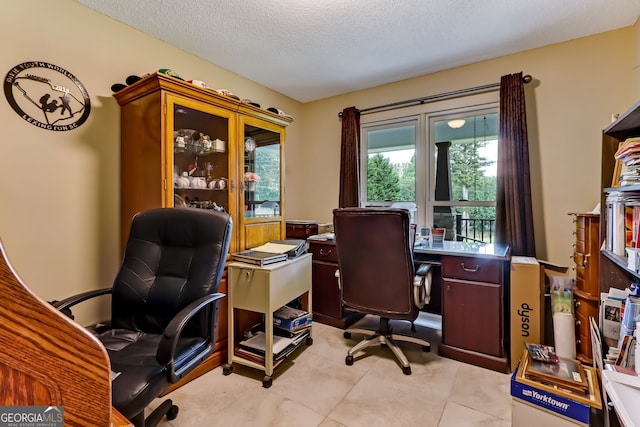 office area featuring a textured ceiling and light tile patterned floors