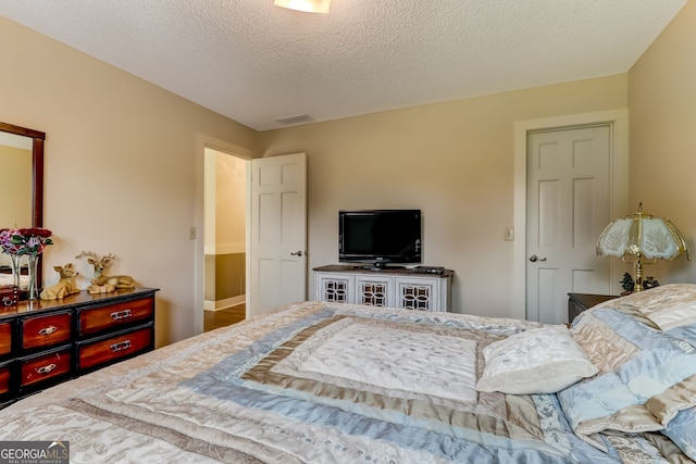 bedroom with a textured ceiling and visible vents