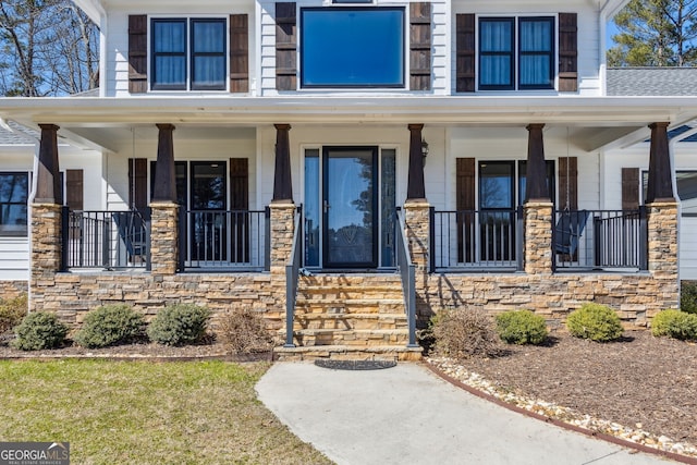 entrance to property with stone siding and covered porch