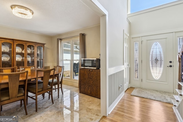 interior space with a decorative wall, light wood-style flooring, and crown molding