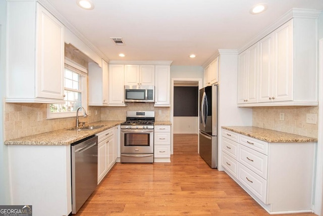 kitchen featuring white cabinets, visible vents, stainless steel appliances, and a sink