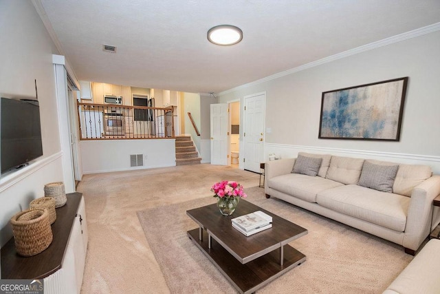 living room with carpet, visible vents, crown molding, and stairs