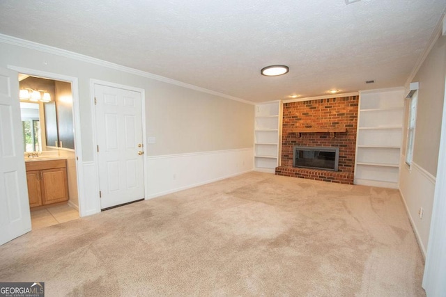 unfurnished living room featuring built in shelves, a brick fireplace, light carpet, and ornamental molding