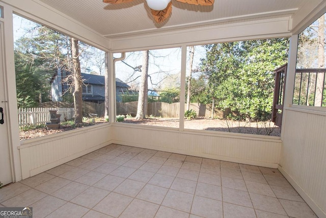 unfurnished sunroom with ceiling fan