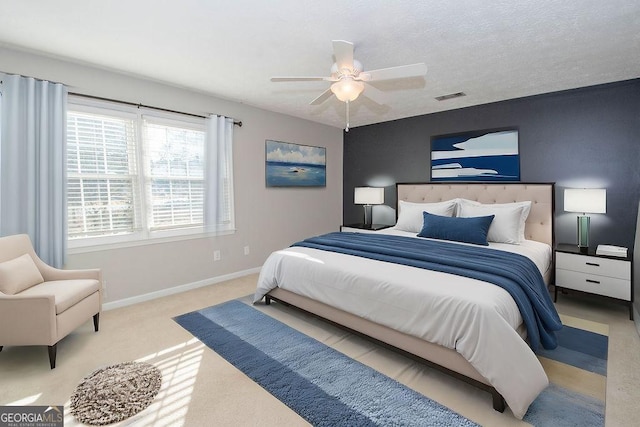 carpeted bedroom featuring a ceiling fan, visible vents, and baseboards