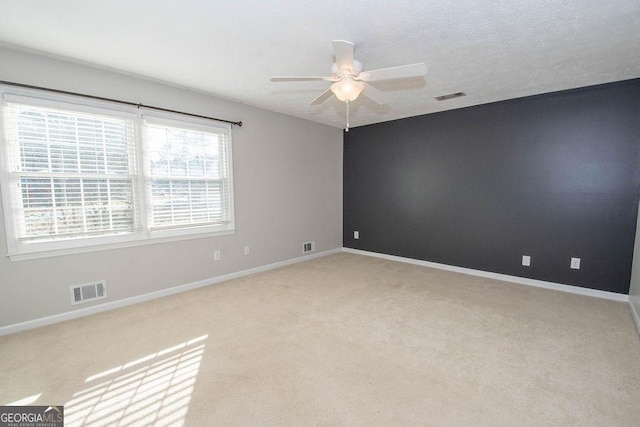 empty room featuring carpet flooring, visible vents, and baseboards