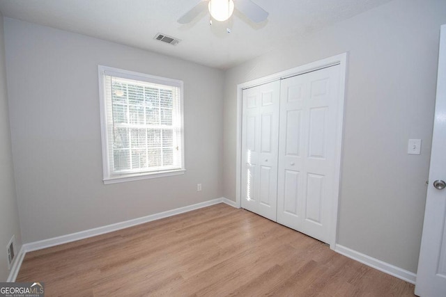 unfurnished bedroom featuring a closet, light wood-type flooring, visible vents, and baseboards