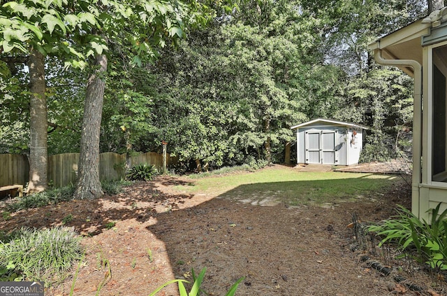 view of yard with a storage shed, an outbuilding, and fence