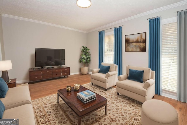 living area with ornamental molding, light wood finished floors, and baseboards