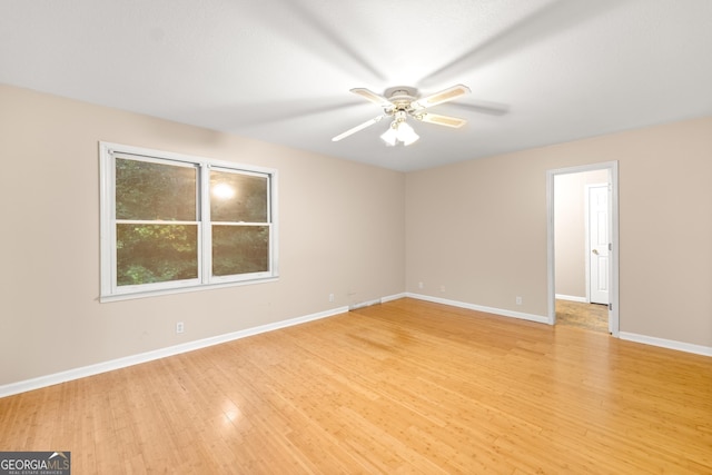 empty room featuring light wood-style floors, baseboards, and a ceiling fan