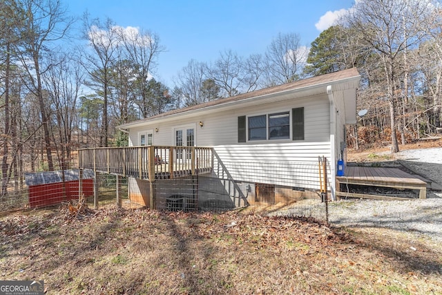 back of property featuring french doors, crawl space, and a wooden deck