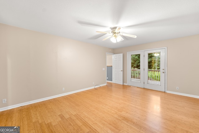 empty room featuring light wood-type flooring, a ceiling fan, and baseboards