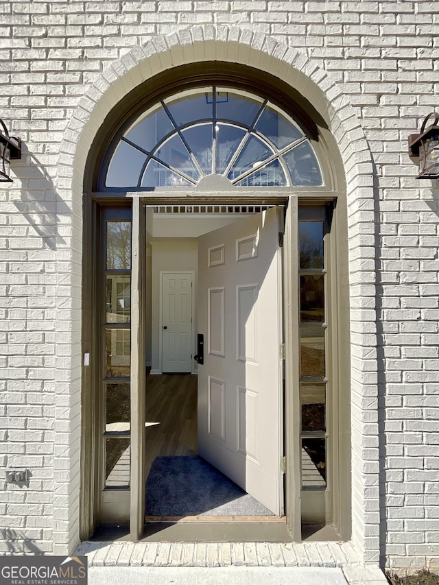 doorway to property featuring brick siding