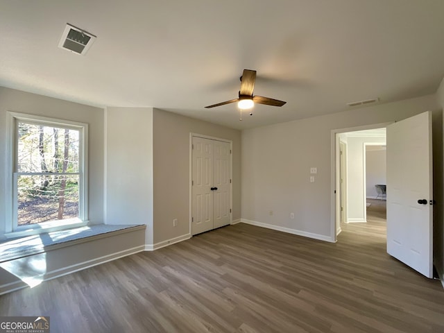 interior space with wood finished floors, visible vents, and baseboards