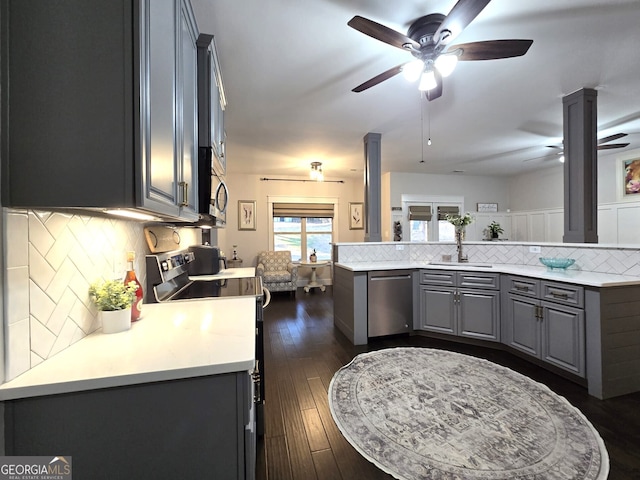 kitchen with tasteful backsplash, appliances with stainless steel finishes, light countertops, and gray cabinetry