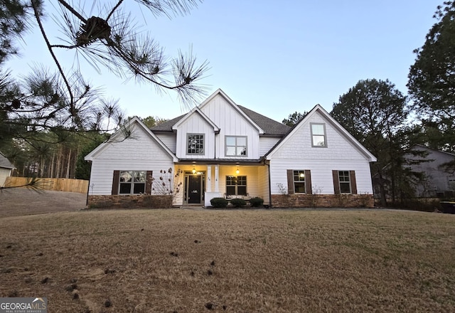 modern farmhouse style home featuring a front lawn and board and batten siding