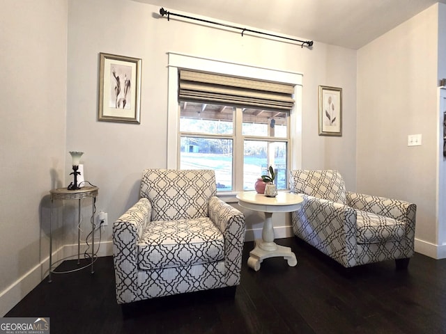 living area with baseboards and wood finished floors