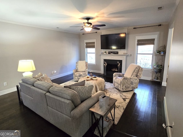 living area with a wealth of natural light, a fireplace, and crown molding