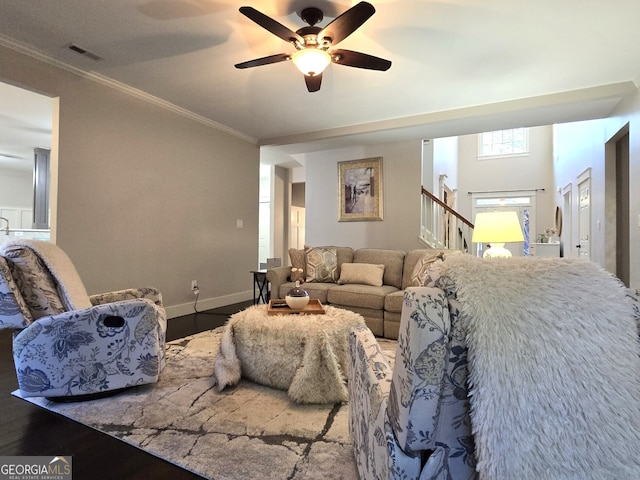 living room with stairs, baseboards, crown molding, and wood finished floors