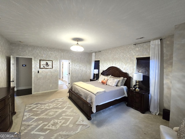 carpeted bedroom with visible vents and wallpapered walls