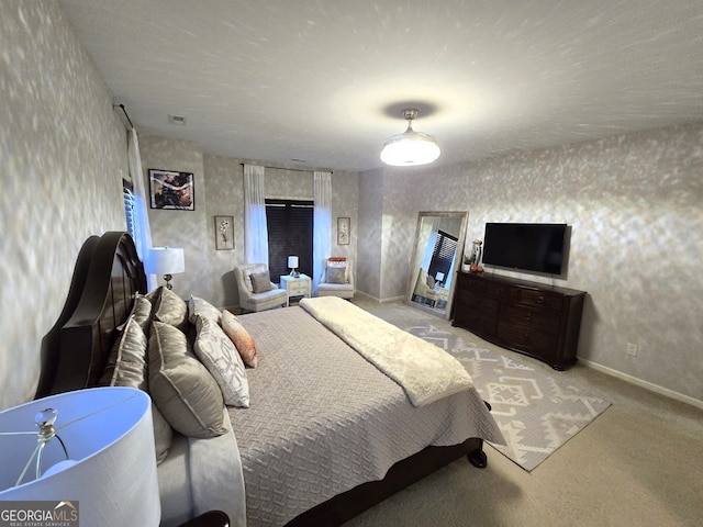 bedroom featuring light colored carpet, visible vents, baseboards, and wallpapered walls