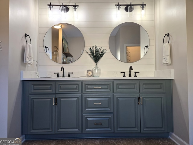 full bath featuring a sink, baseboards, and double vanity