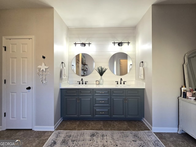 full bathroom featuring double vanity, a sink, and baseboards