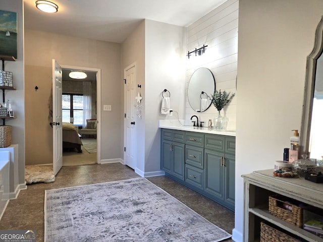 ensuite bathroom with ensuite bath, baseboards, and vanity