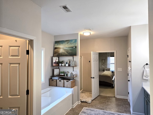 full bathroom with a garden tub, ensuite bath, visible vents, and baseboards