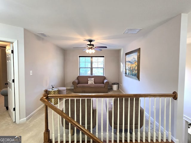 interior space featuring a ceiling fan, carpet, visible vents, and baseboards