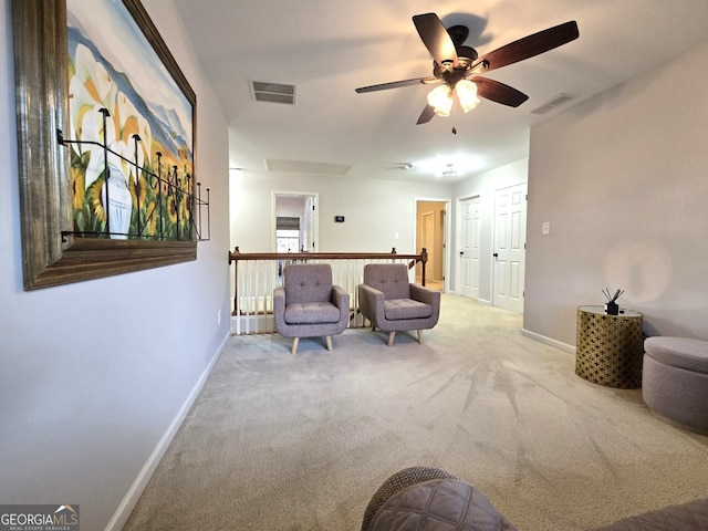 sitting room featuring carpet floors, visible vents, and baseboards