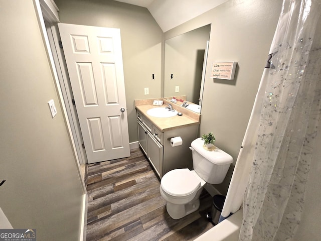 full bathroom with toilet, a shower with shower curtain, wood finished floors, and vanity