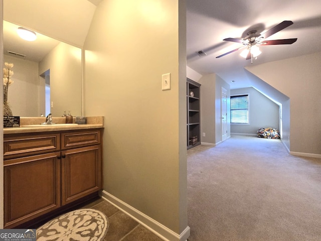 bathroom with visible vents, baseboards, a ceiling fan, vaulted ceiling, and vanity