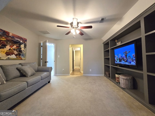 carpeted living area featuring built in shelves, visible vents, baseboards, and a ceiling fan