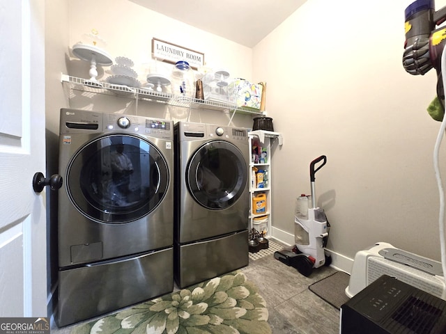 laundry area featuring laundry area, baseboards, and washing machine and clothes dryer