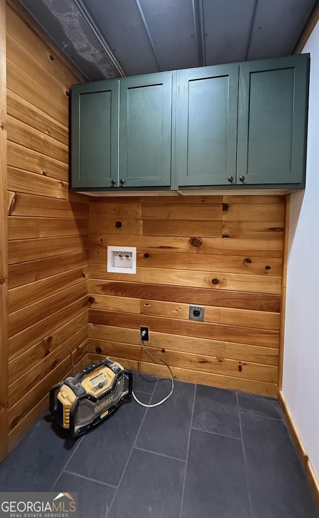 laundry area featuring dark tile patterned flooring, hookup for a washing machine, cabinet space, and hookup for an electric dryer