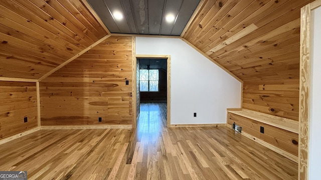 bonus room featuring lofted ceiling, light wood-style flooring, wood ceiling, and wooden walls