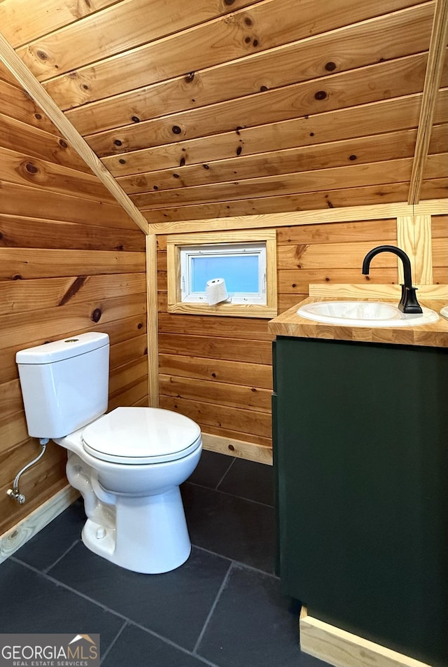 bathroom with wooden ceiling, toilet, wooden walls, vanity, and tile patterned floors