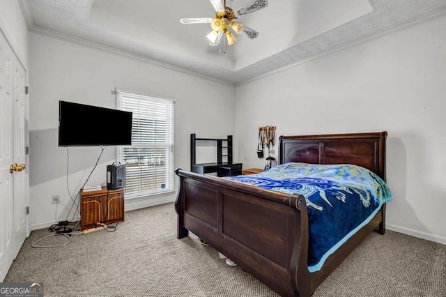 bedroom with ornamental molding, carpet flooring, a raised ceiling, and baseboards