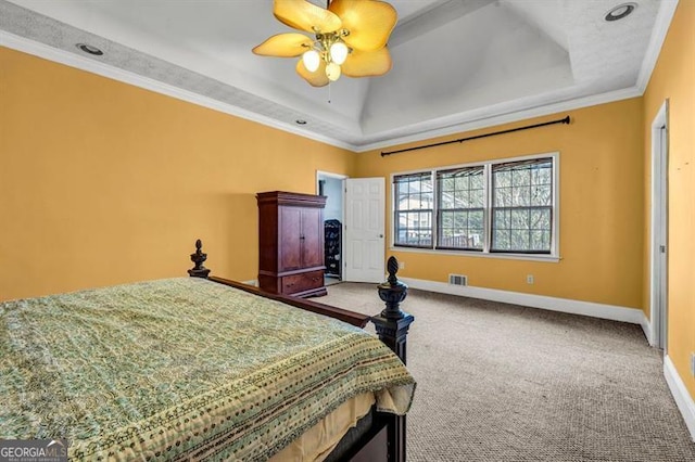 carpeted bedroom with ornamental molding, a tray ceiling, ceiling fan, and baseboards