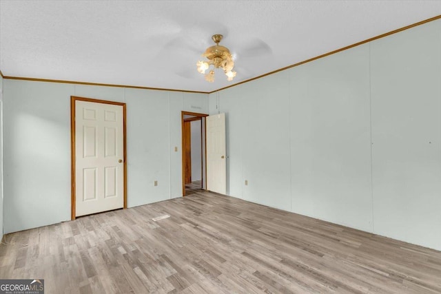 unfurnished bedroom with light wood finished floors, a ceiling fan, and crown molding