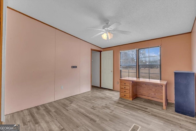 unfurnished office featuring lofted ceiling, visible vents, light wood-style flooring, ceiling fan, and a textured ceiling