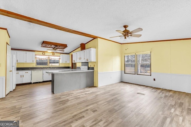 kitchen with light wood-style flooring, white cabinetry, vaulted ceiling, a textured ceiling, and white appliances