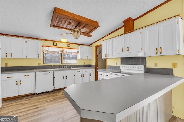 kitchen with white appliances, white cabinets, lofted ceiling, a peninsula, and a textured ceiling