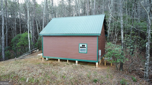 view of outdoor structure featuring a forest view and an outbuilding