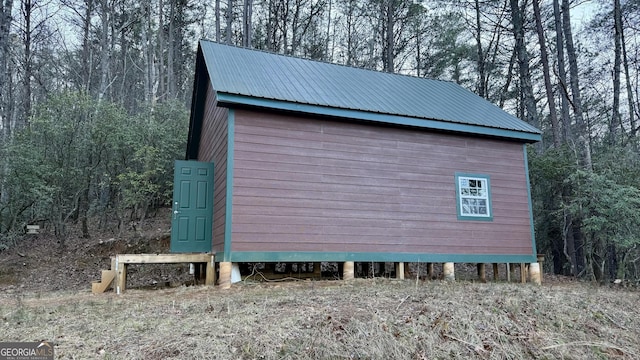 view of home's exterior featuring metal roof and an outdoor structure